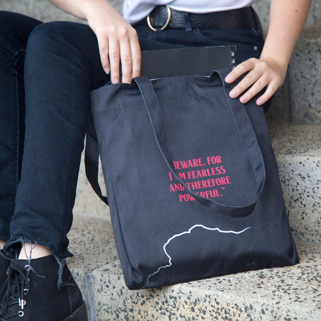 Frankenstein Black Tote Bag by Mary Shelley featuring Lightning Flash design, by Well Read Co. - Girl Sitting