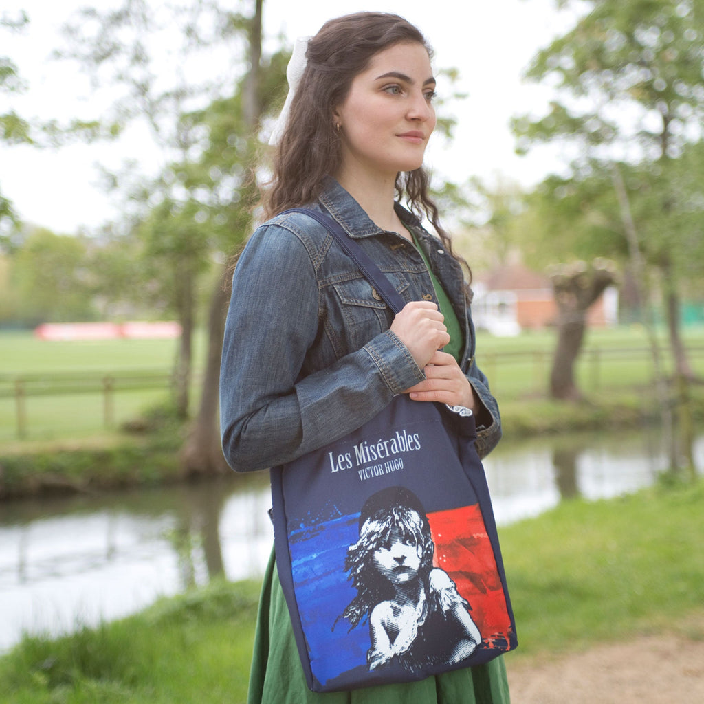 Les Misérables Navy Tote Bag by Victor Hugo featuring Cosette over French flag design, by Well Read Co. - Model Standing