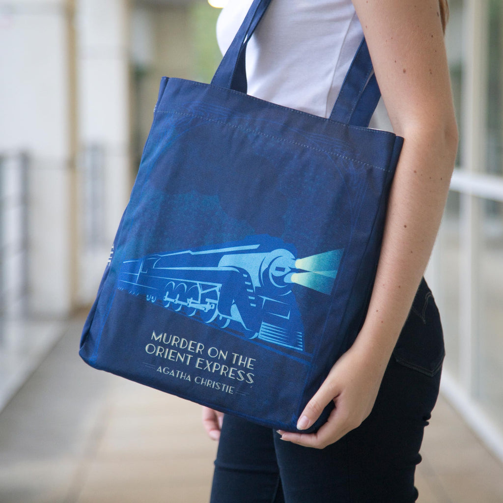 The Murder on the Orient Express Blue Tote Bag by Agatha Christie featuring Steam Train design, by Well Read Co. - Model Standing with Bag