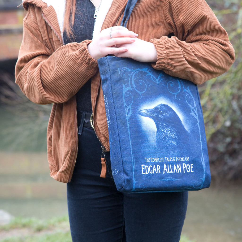 Collection of Tales and Poems Blue Tote Bag by Edgar Allen Poe featuring Raven design, by Well Read Co. - Model